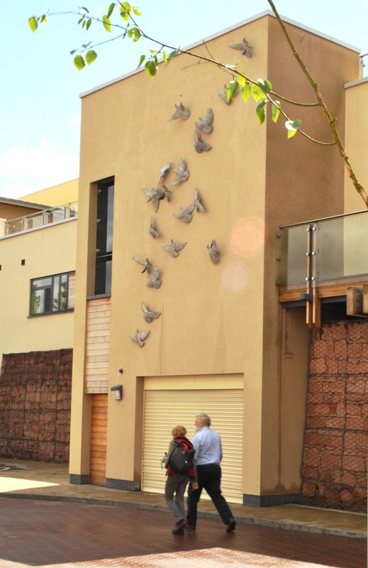Bronze birds flying up the wall.