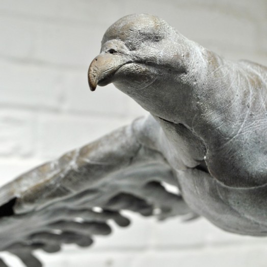 BIRD IN HAND - Detail: a bronze bird in flight made out of hand prints